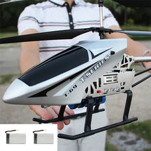 Person holding a T-Series RC helicopter with a blurred background