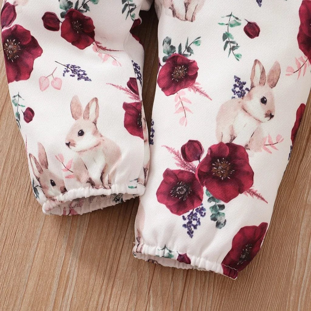 Pair of oven mitts with rabbit and floral design on a wooden surface