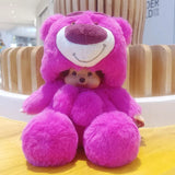 Pink plush toy with a smiling face on a wooden surface