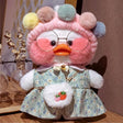 Plush toy with a floral dress and round glasses on a wooden surface.