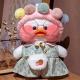 Plush toy with a floral dress and round glasses on a wooden surface.