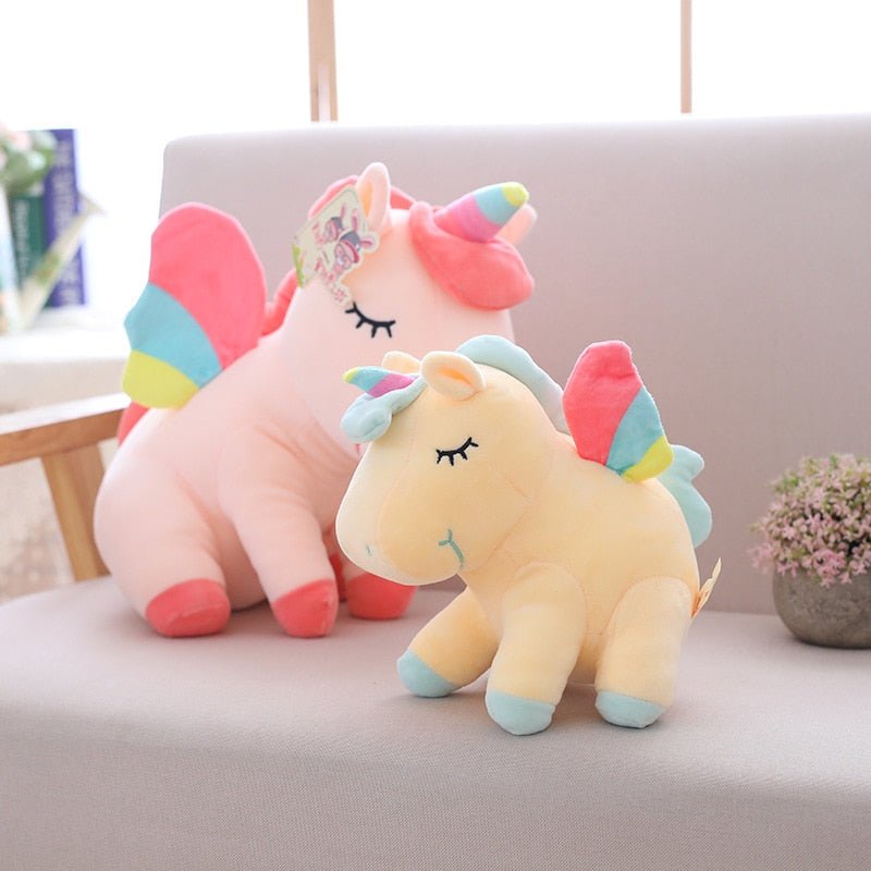 Two colorful unicorn plush toys on a couch with a blurred background