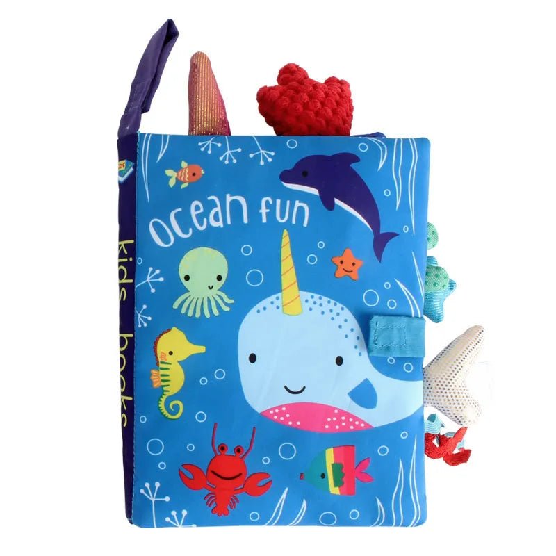 Children's soft book with ocean-themed illustrations and toys on a white background