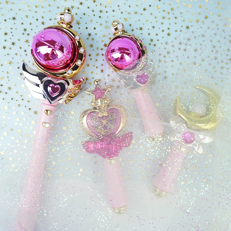 Pink orb and pink glitter heart wands with a gold moon wand on a glittery background