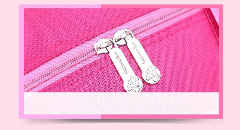 Close-up of a pink pouch with silver zippers and tags.
