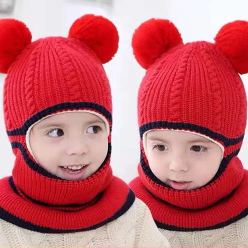 Two children wearing red knitted hats with pom-poms on a white background