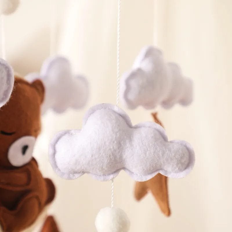 Felt plush pendant detail from the baby crib mobile, a soft hanging piece that catches infant attention above the cot.