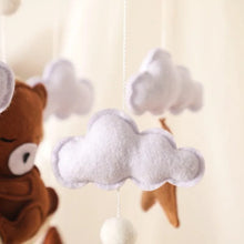 Felt plush pendant detail from the baby crib mobile, a soft hanging piece that catches infant attention above the cot.