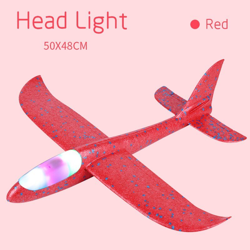 Red toy airplane with a headlight on a pink background