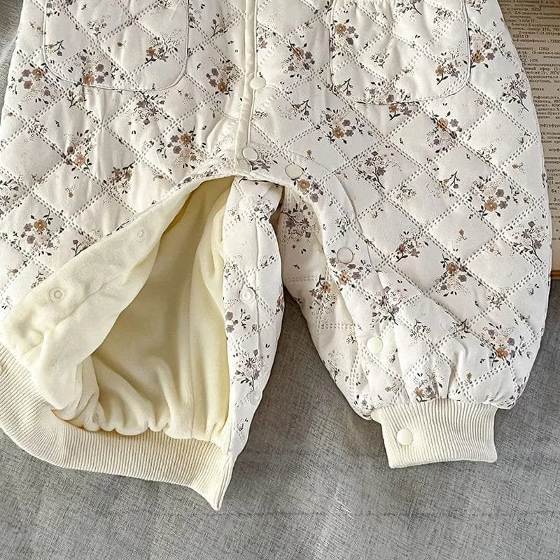Padded floral quilted baby romper detail, showing the insulated winter jumpsuit built for warmth during stroller walks.