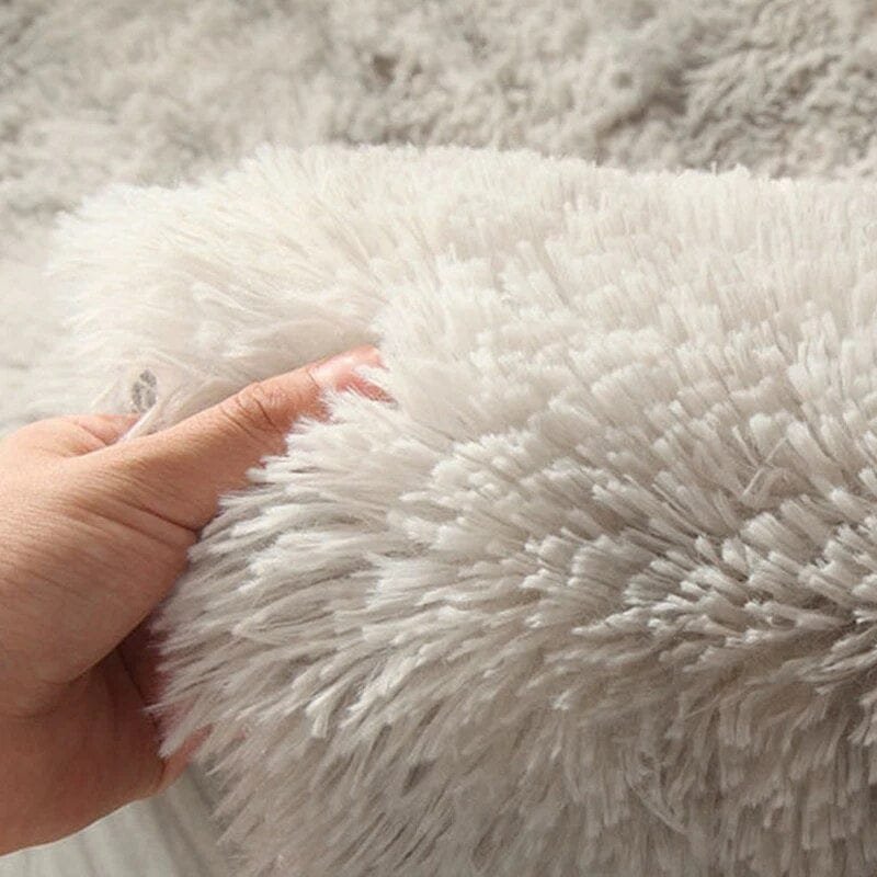 Close-up of a hand touching a fluffy rug.
