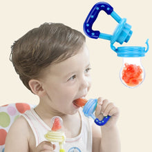 Child holding a blue baby feeder with a small container of red fruit puree.