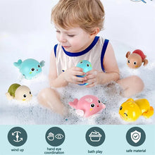 Frogs Clockwork Swimming Bath Toy in use as a child plays in a bubble bath surrounded by colorful toys.