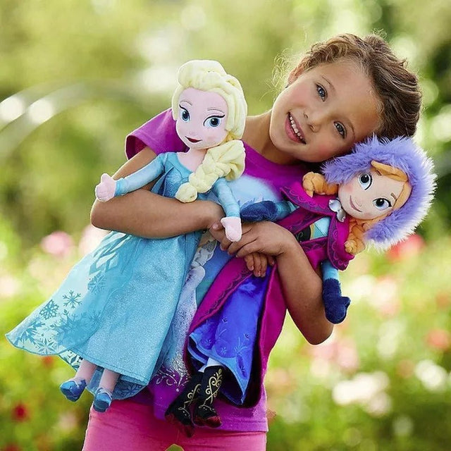 Child holding two dolls in a garden setting