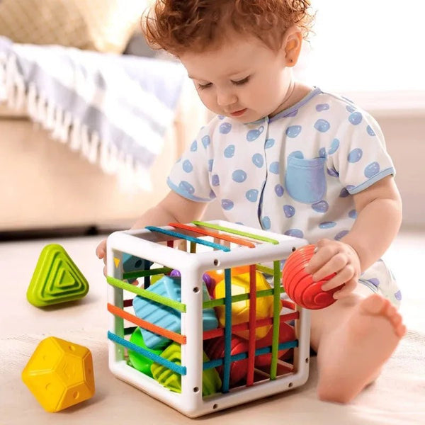 Child playing with a colorful toy cube.