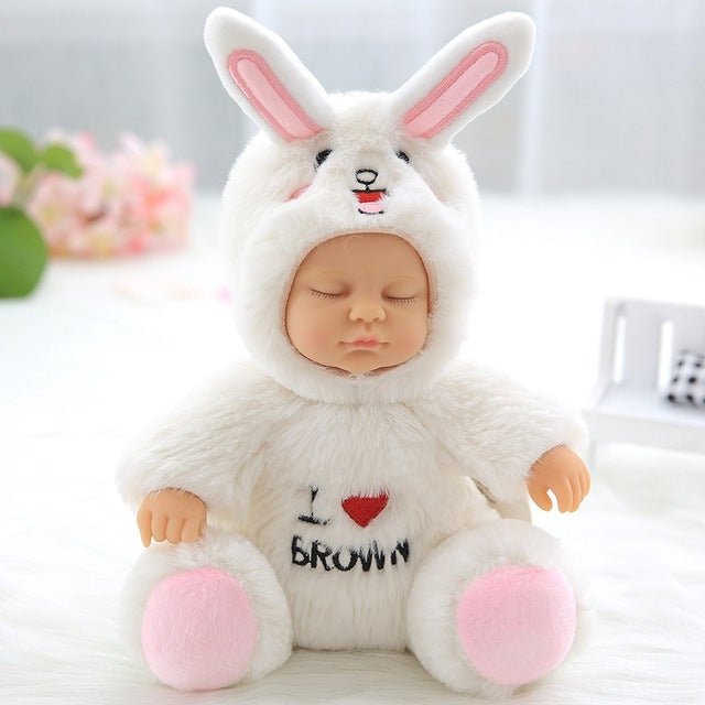 Baby in a white bunny costume with pink ears and paws, sitting on a light surface.