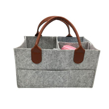 Gray foldable diaper caddy basket with brown leather handles for easy nursery carrying.