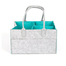 Gray felt tote bag with teal interior lining used as a hanging changing table organiser.