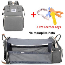 Mommy bag with portable crib bed for babies in gray, packed with crib and teether accessories.