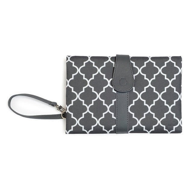 Compact foldable diaper changing mat and waterproof pad in gray pattern with wrist strap for outings.