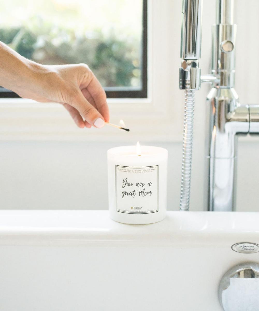 Candle being lit on a kitchen counter with a message on the label.