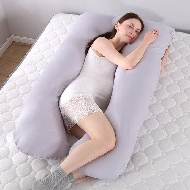 Grey U shaped body pillow for pregnancy side sleeping with a cushion between the legs for hip relief.