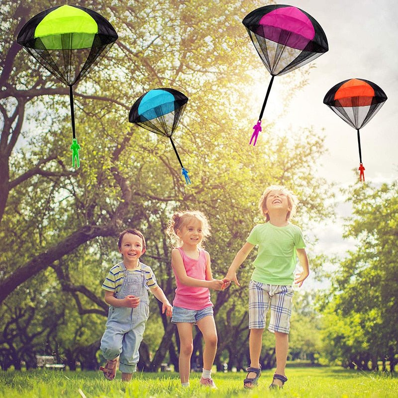 Children playing with colorful parachutes in a park