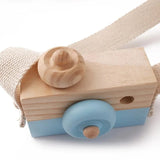 Wooden toy camera with a blue lens.