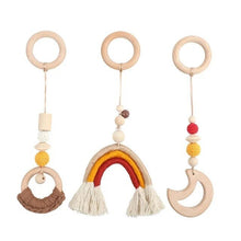 Three wooden baby rattle toys with colorful beads and tassels.