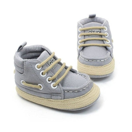 Pair of gray baby sneakers with beige soles 