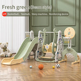 Children's playset with slide, swing, and basketball hoop in a room.