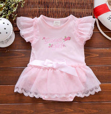 Pink baby dress with ruffled sleeves and a bow on a wooden surface (option 4)