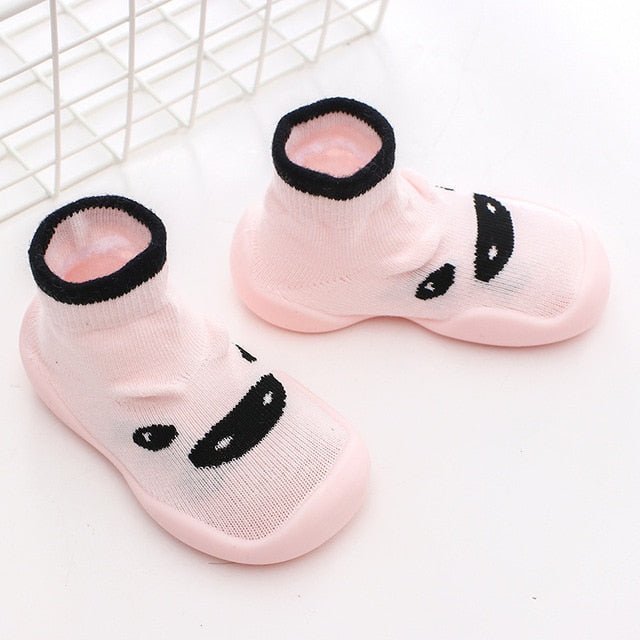 Pink socks with black panda face design on a white background