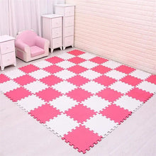 Pink and white checkered foam mats on a floor with a pink chair and cabinet in the background.