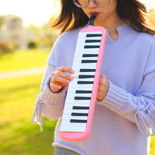 Person playing the pink IRIN Melodica Keyboard outdoors for kids music learning and practice.