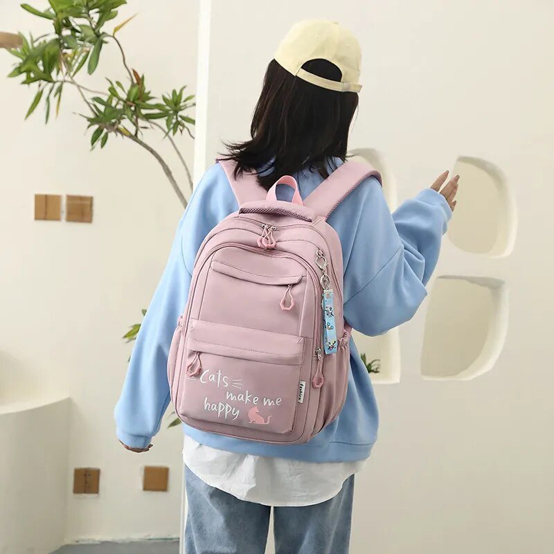 Person wearing a pink backpack with text, standing indoors.