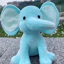 Kawaii Elephant plush toy in blue seated on a concrete surface for outdoor photo styling and play.