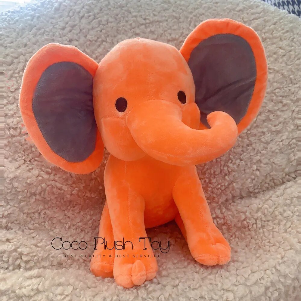 Kawaii Elephant plush toy in orange on a textured surface, a Coco Plush Toy snuggle buddy.