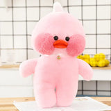 Pink plush toy with a white hat on a wooden surface.