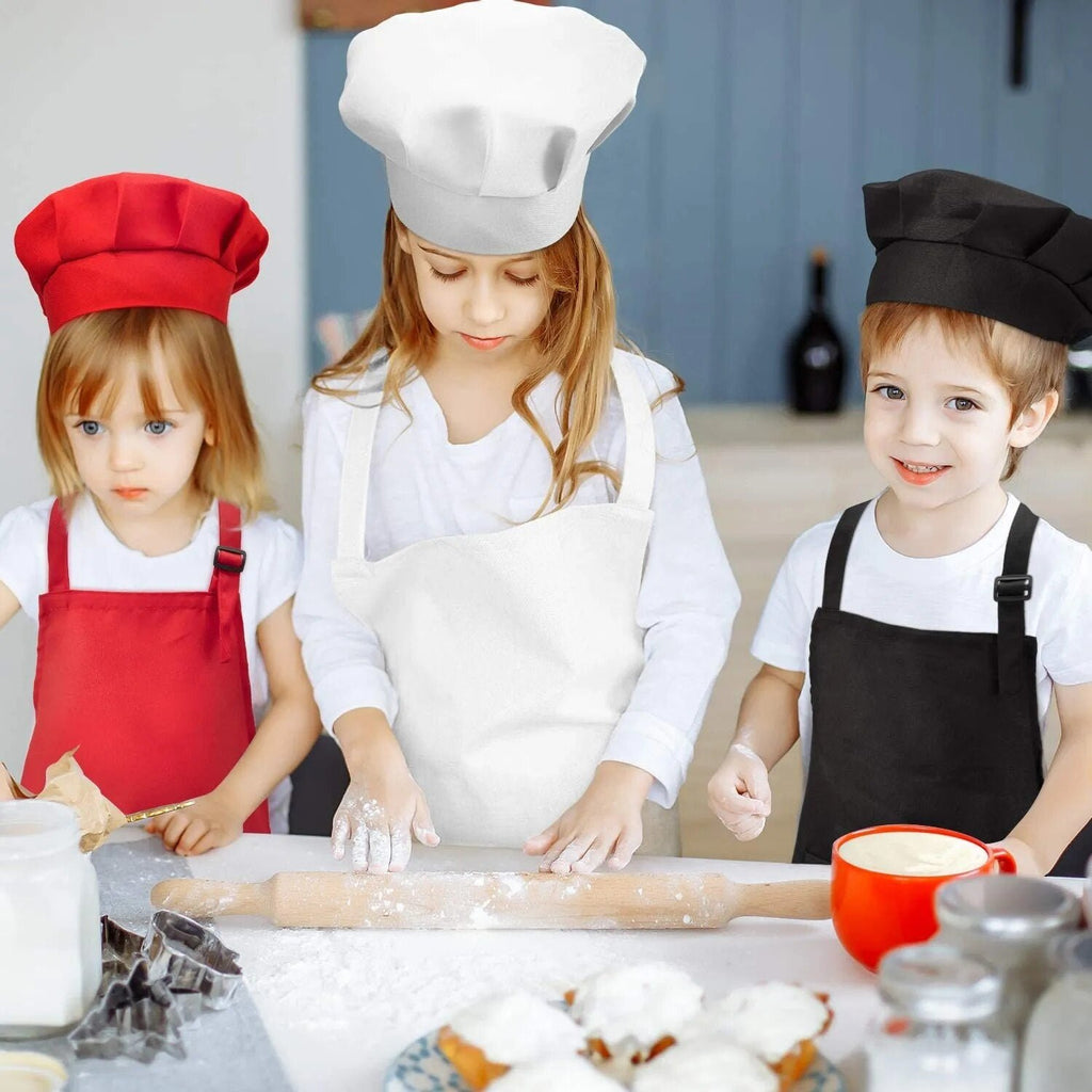 4pcs Kids Apron Set with chef hats worn by children at a kitchen counter, ideal for baking together and messy cooking lessons.