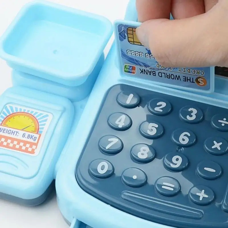 Close-up of the toy cash register keypad and scale tray with a bank card being swiped