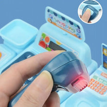 Hand holding the toy scanner with a red light on a light blue cash register