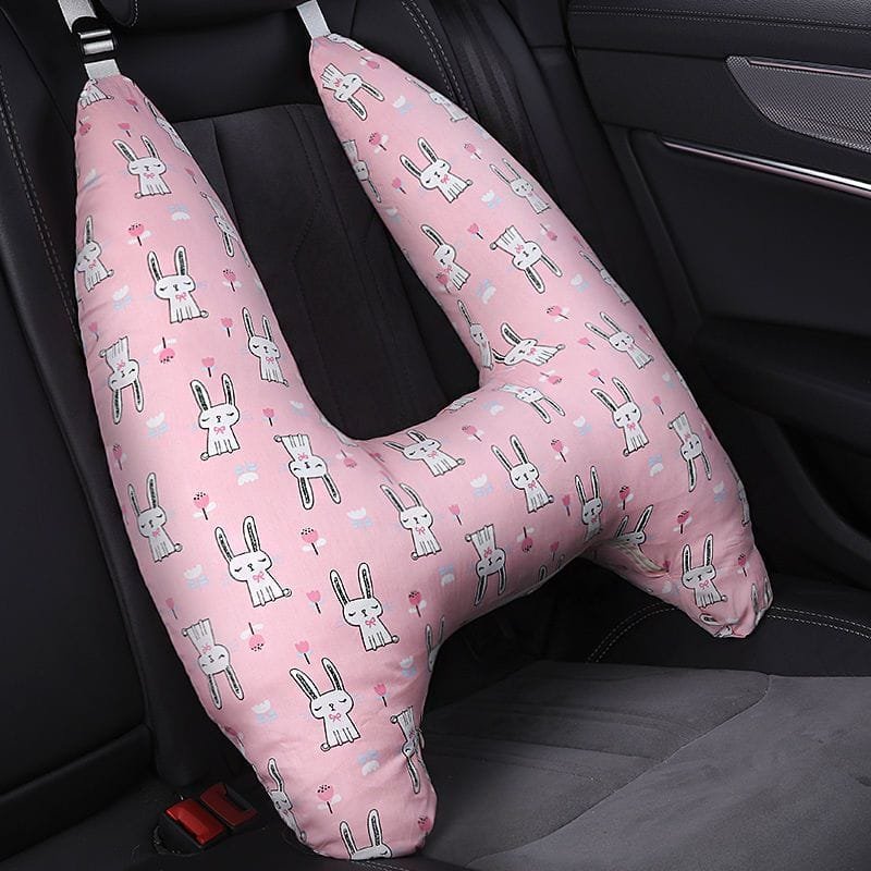 Pink U-shaped car pillow with rabbit pattern on a car seat