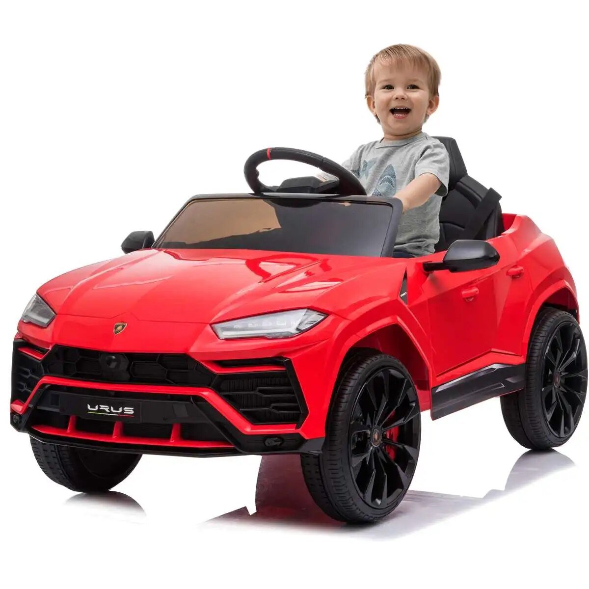 A child sitting in a red toy car.
