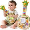 Smiling baby holding a green giraffe toy guitar beside the guitar with farm animal buttons