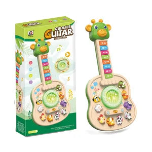 Green giraffe toy guitar next to its box on a white background