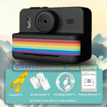 Black instant print camera with a yellow lanyard, three paper rolls, a USB cable and a manual