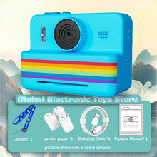 Bright blue instant print camera with a blue lanyard, three paper rolls, a USB cable and a manual