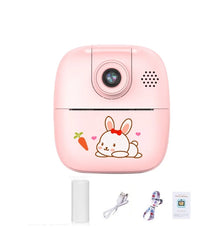 Pink bunny kids camera with a paper roll, USB cable, lanyard and manual below it