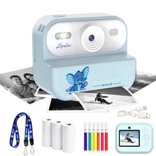 Light blue instant print camera with a skiing print, a lanyard, paper rolls, colored pens and a USB cable